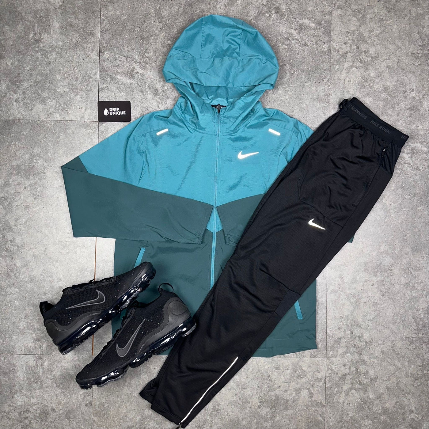 Men's Nike UV Windrunner Jacket in a Teal Colorway paired with the Nike Phenom Pants in a black colorway and the Nike Vapormax in Black, dripuniqueuk