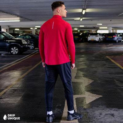 Men's Nike Therma 1/4 Zip Top in a Red colourway, being modelled, showcasing the rear design of the nike therma 1/4 zip in red and the black nike elite phenom pants, dripuniqueuk