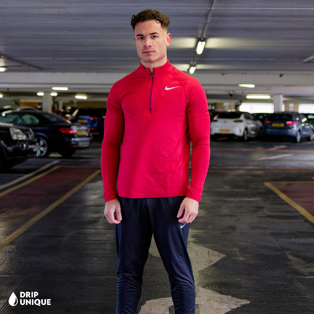 Men's Nike Therma 1/4 Zip Top in a Red colourway, being modelled, showcasing the front design of the nike therma 1/4 zip in red and the black nike elite phenom pants, dripuniqueuk